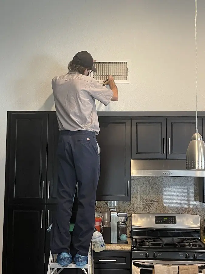 Technician inspecting an air vent during HVAC service in Taylor Mill